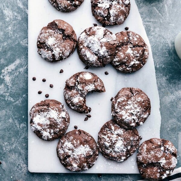 Fresh out of the oven, chocolate crinkle cookies dusted with powdered sugar, exuding a warm and inviting aroma.