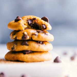 Stacked small batch pumpkin cookies with the top one featuring a missing bite, showcasing their texture.