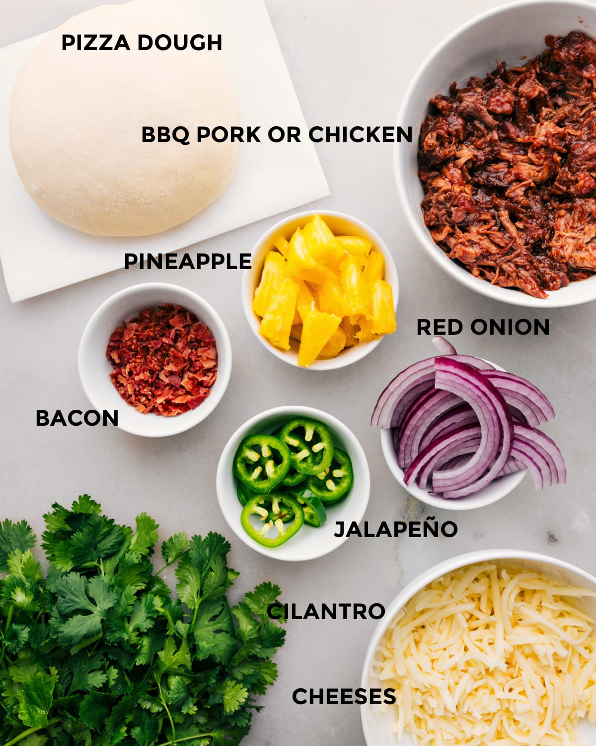 All the ingredients for this recipe are prepped for easy assembly, including the dough, meat, pineapple, red onion, jalapeno, cheese, and cilantro.