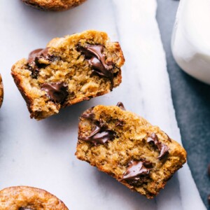 Peanut butter banana muffin broken open, revealing the delicious interior with melting chocolate chips.