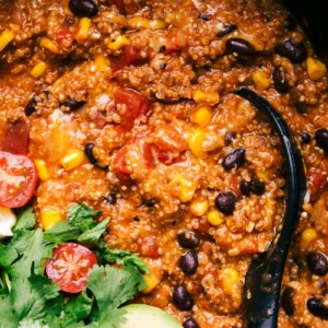 Finished enchilada quinoa dish in a crockpot, rich and flavorful, with a spoon nestled inside, ready for serving.