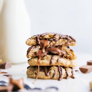 Ready-to-eat caramel oatmeal cookies stacked on top of each other, with one broken in half to reveal the gooey caramel center.