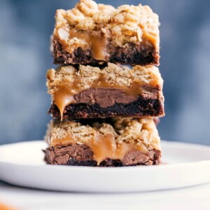 Chocolate chip brownie cookie bars ready to be eaten, with caramel oozing from the center.