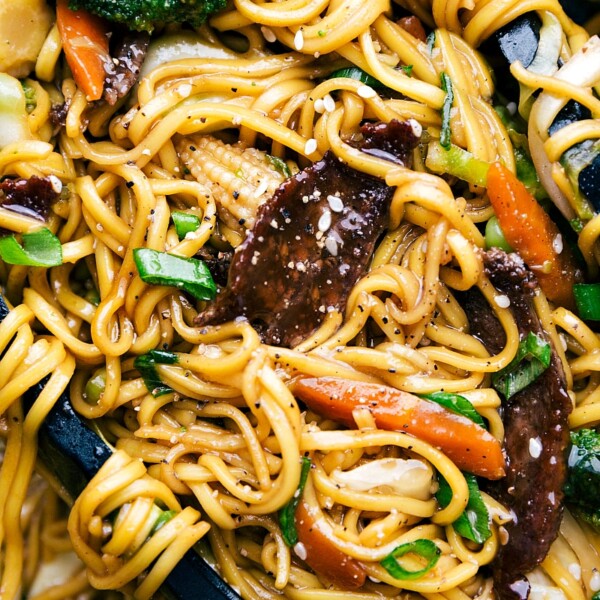 Finished Beef Chow Mein with tongs holding the noodles.