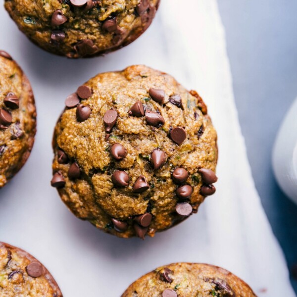 Gluten free zucchini muffins freshly out of the oven, topped with mini chocolate chips, ready to be enjoyed as a delicious breakfast or snack.