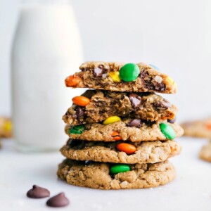 Healthy Monster Cookies stacked on top of each other with one broken in half showing off the middle.