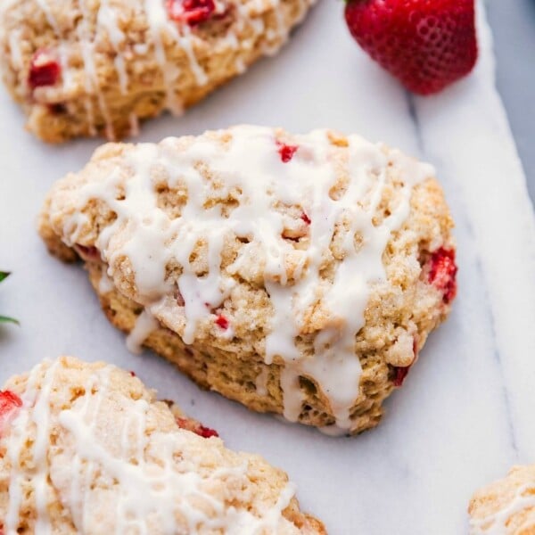 Freshly baked strawberry scones with glaze on top, ready to be enjoyed.