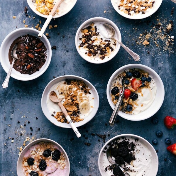 Eight different enticing yogurt bowls with spoons, all set to be enjoyed.