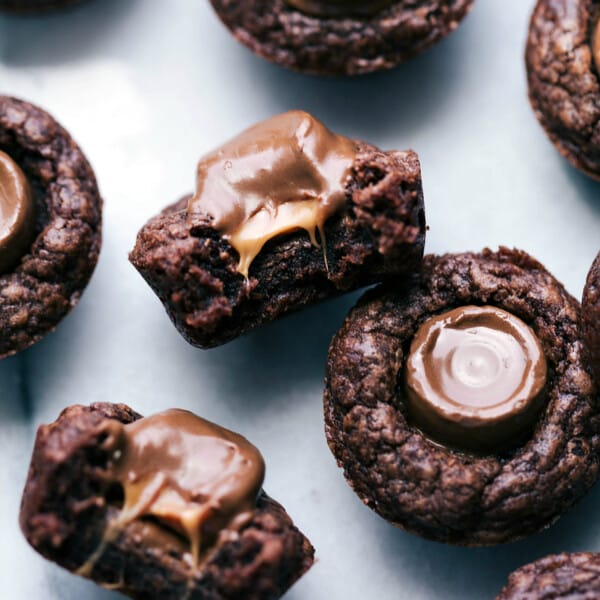 Mini brownie bites with rolos; one is cut in half to expose the gooey, melty insides.