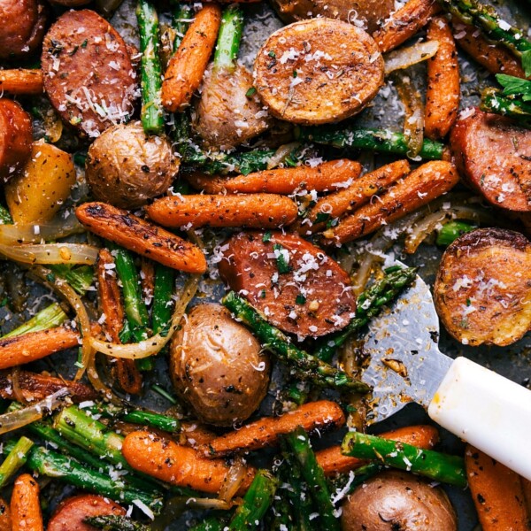 A sheet pan filled with a finished potatoes and sausage dinner, cooked to perfection and seasoned to enhance all the flavors, promising a delicious meal.