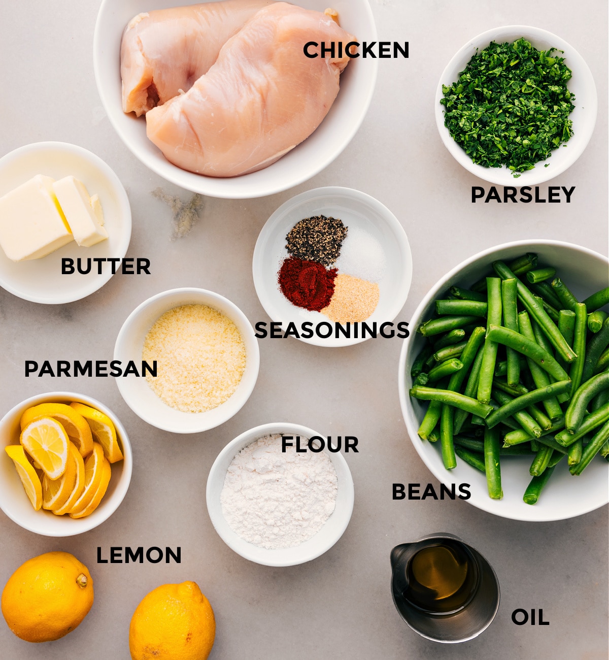 Prep all the ingredients for this recipe, including the meat, beans, parsley, seasonings, butter, flour, cheese, and lemons, for easy assembly.