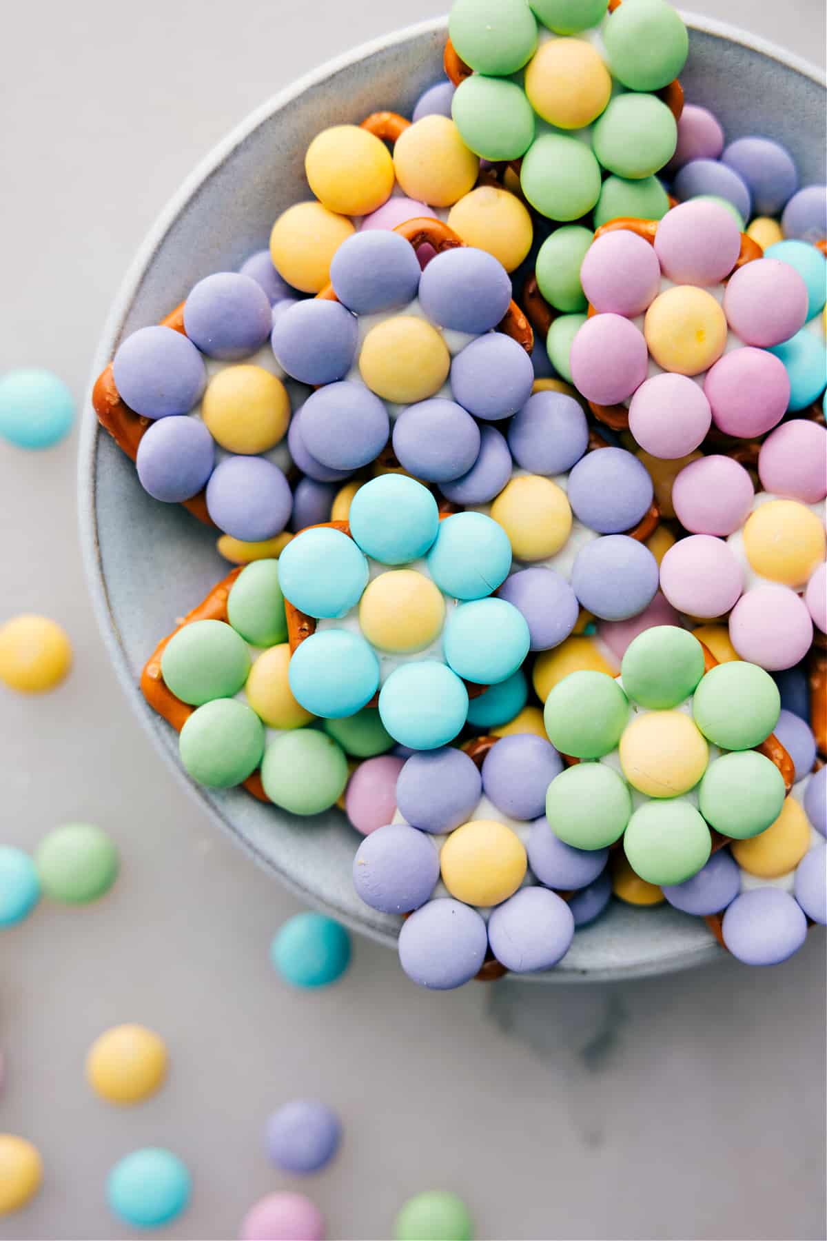 Different colored M&M Flower Pretzels on a plate.