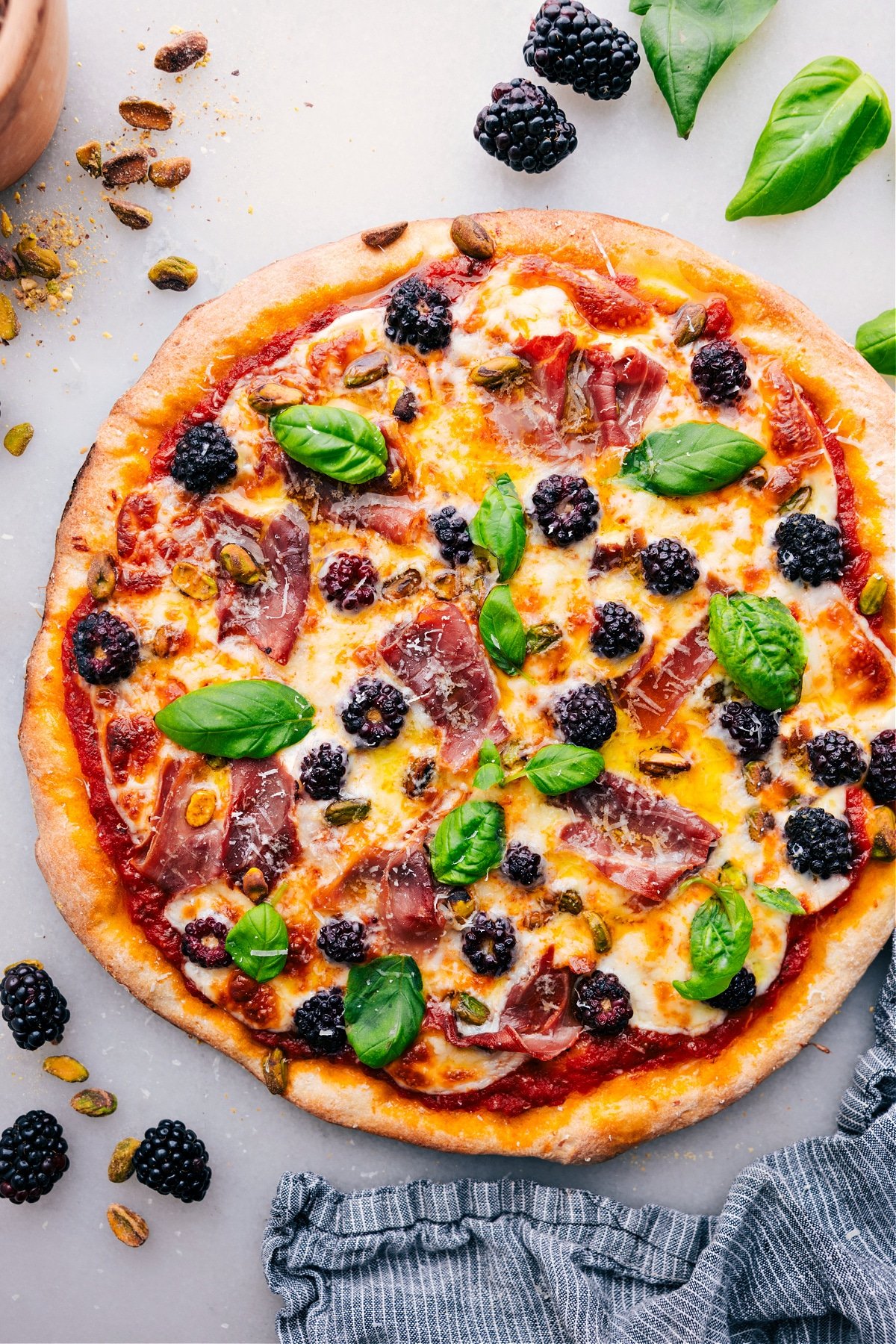 Freshly baked Blackberry Basil Pizza, topped with vibrant fresh basil.