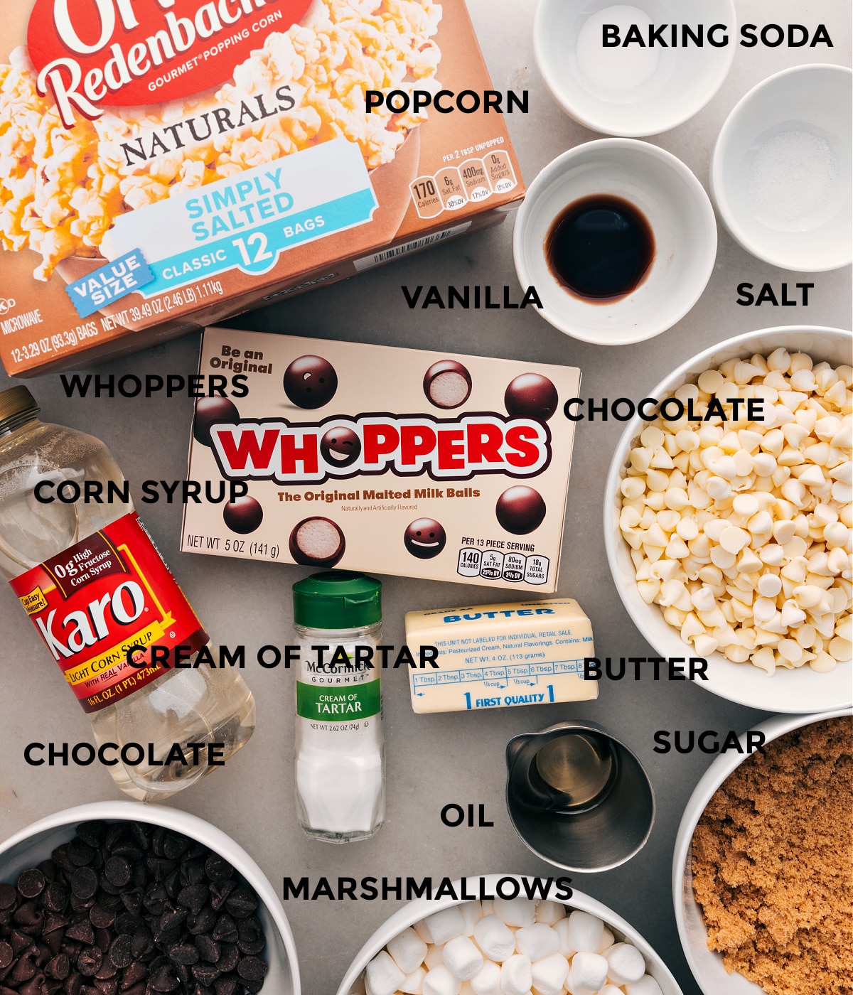 All the ingredients in this recipe are prepped for easy assembly: baking soda, salt, vanilla, popcorn, Whoppers, chocolate, cream of tartar, sugar, corn syrup, and butter.