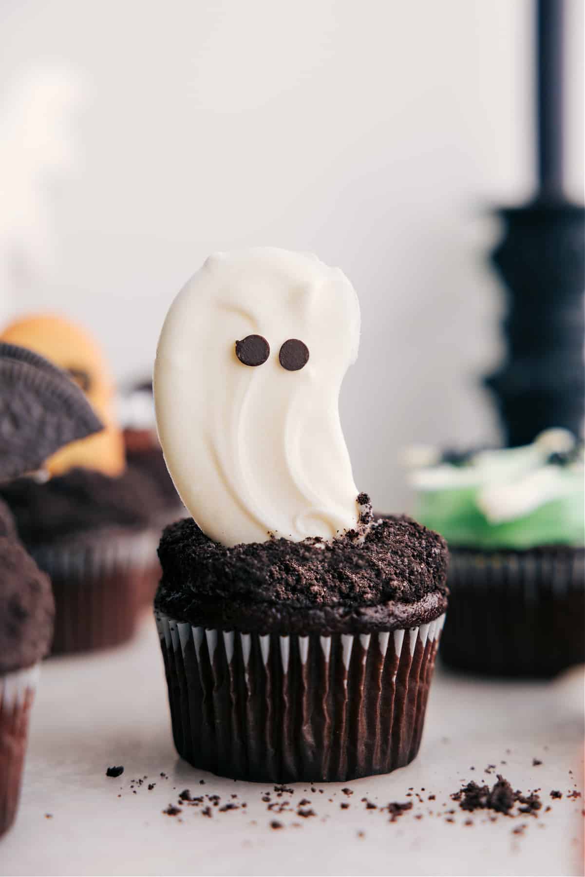 Ghost Halloween cupcakes with white chocolate ghosts and mini chocolate chip eyes.