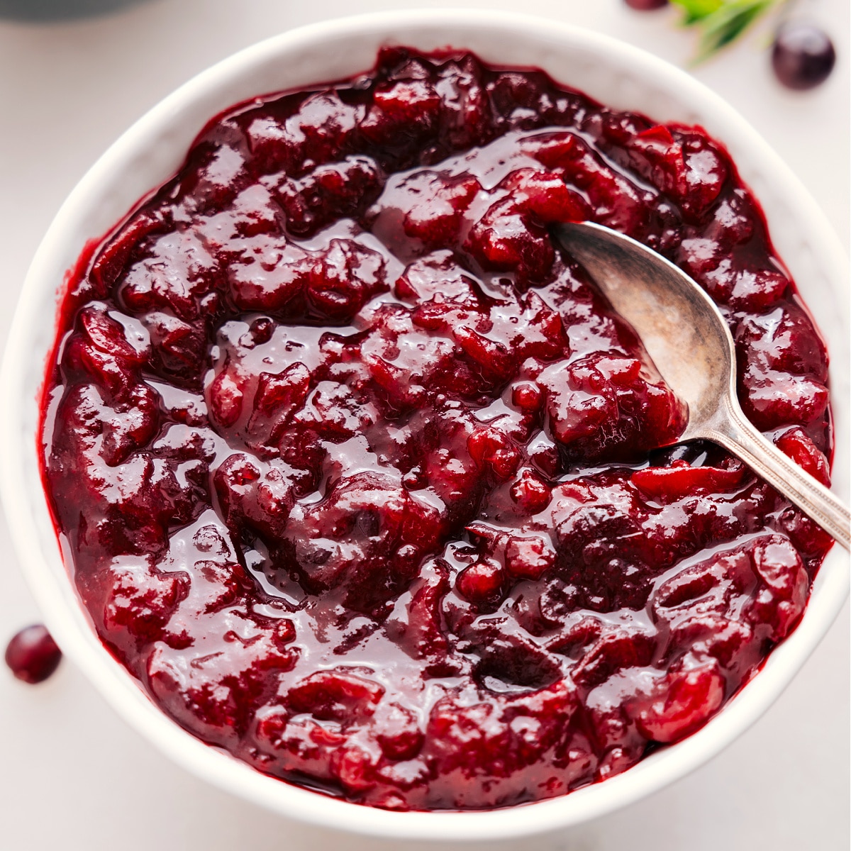 Cranberry sauce in a bowl with a spoon, ready to serve alongside your holiday turkey.