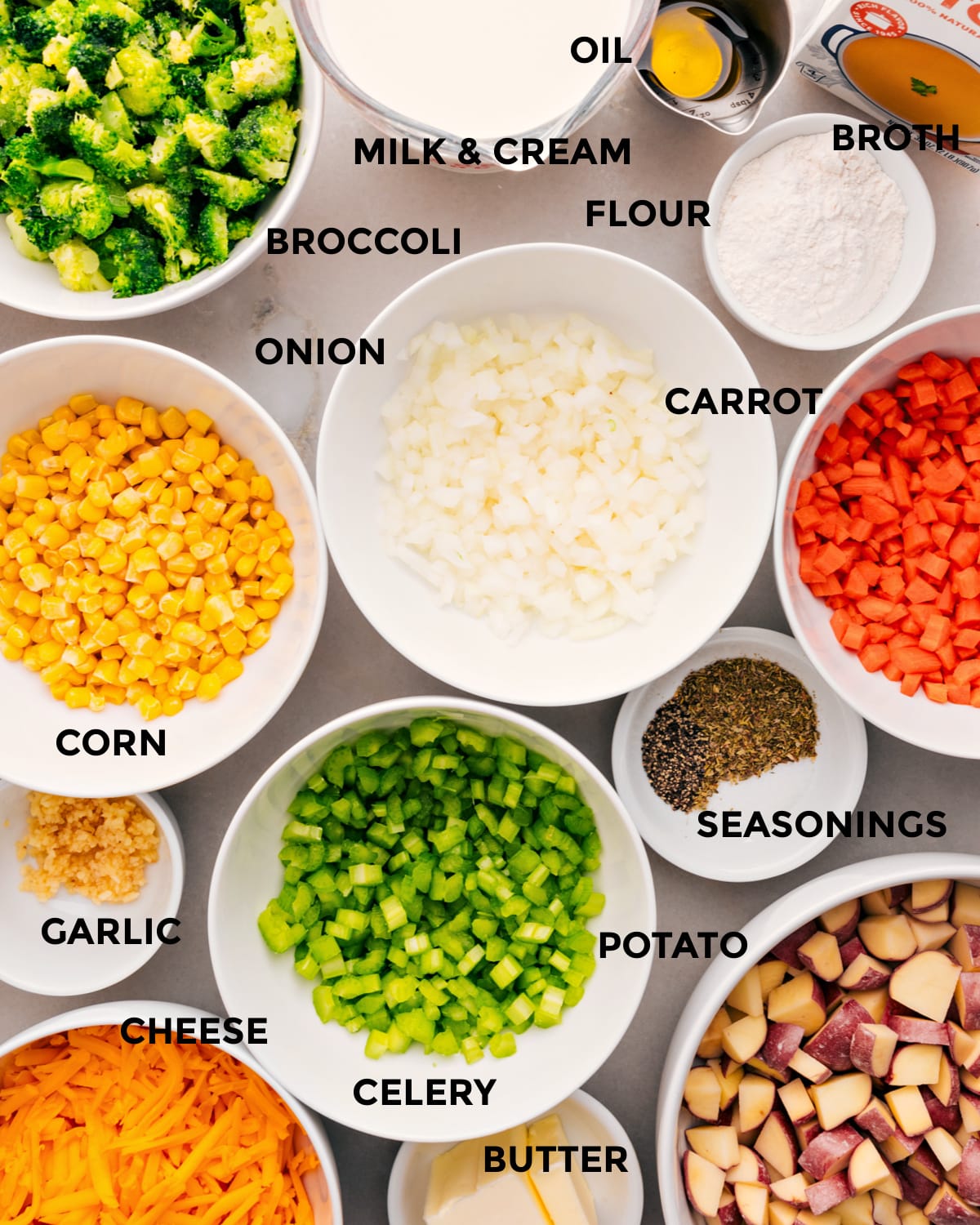 All the ingredients for this recipe are prepped for easy assembly: veggies, flour, broth, milk, cream, seasonings, cheese, and butter.