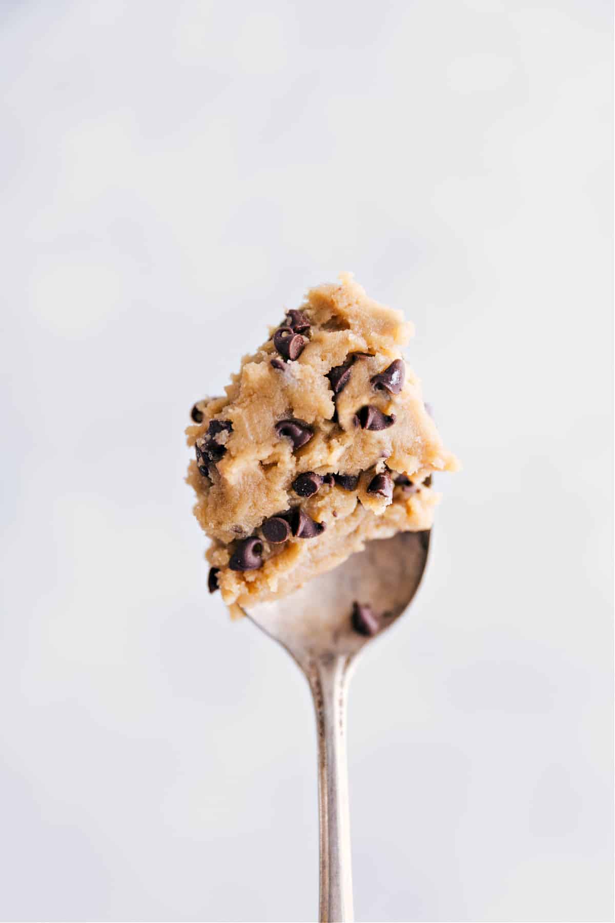 A spoonful of the edible cookie dough being held up.