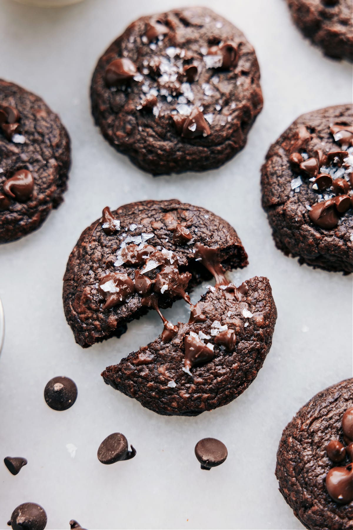 Brownie Cookies recipe on a board freshly baked up with one broken up and chocolate oozing out.