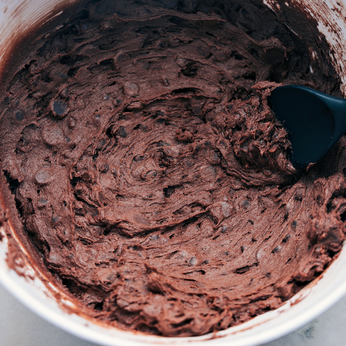 The brownie cookie batter mixed together in a bowl ready to be rolled into balls.