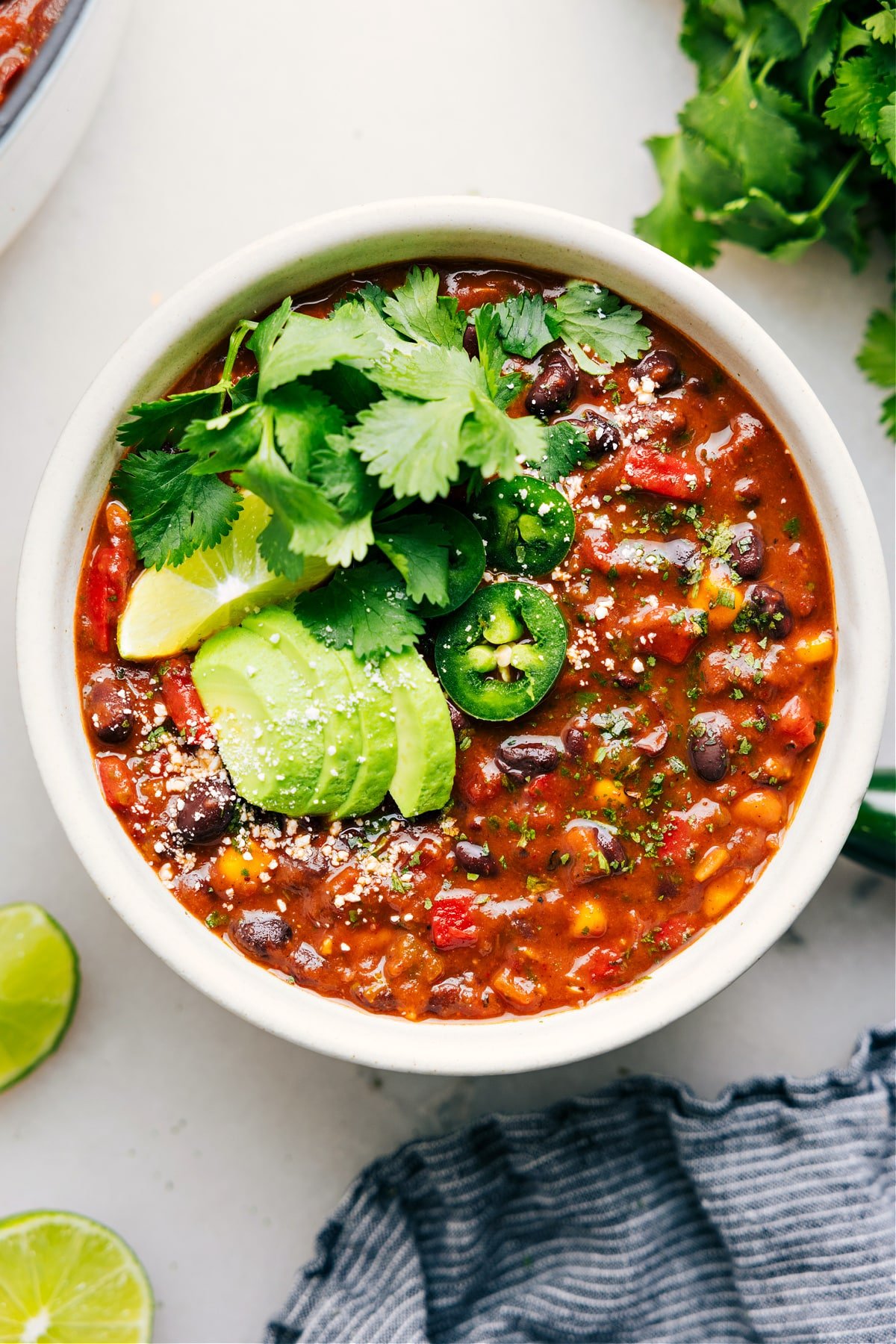 A bowl of vegetarian chili loaded with toppings.