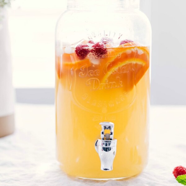 Ready-to-drink punch in a drink dispenser with fresh fruit inside, both delicious and beautiful.