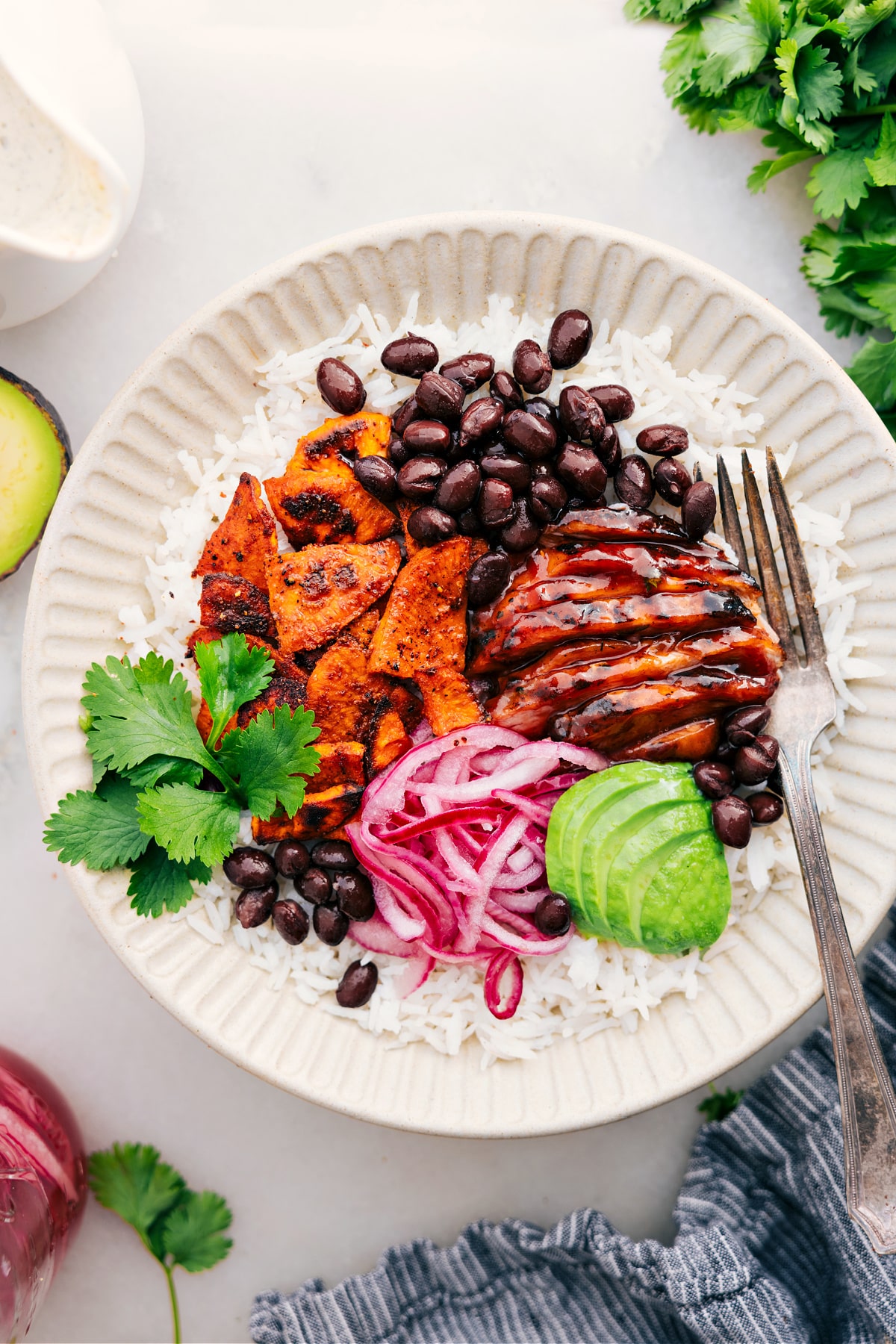 BBQ Chicken Bowl with rice, sweet potatoes, onions, avocado, and beans.