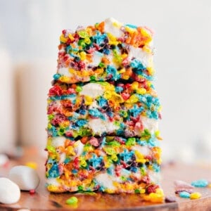 Fruity Pebbles Rice Krispies Treats stacked on top of each other showing the gooey desserts.