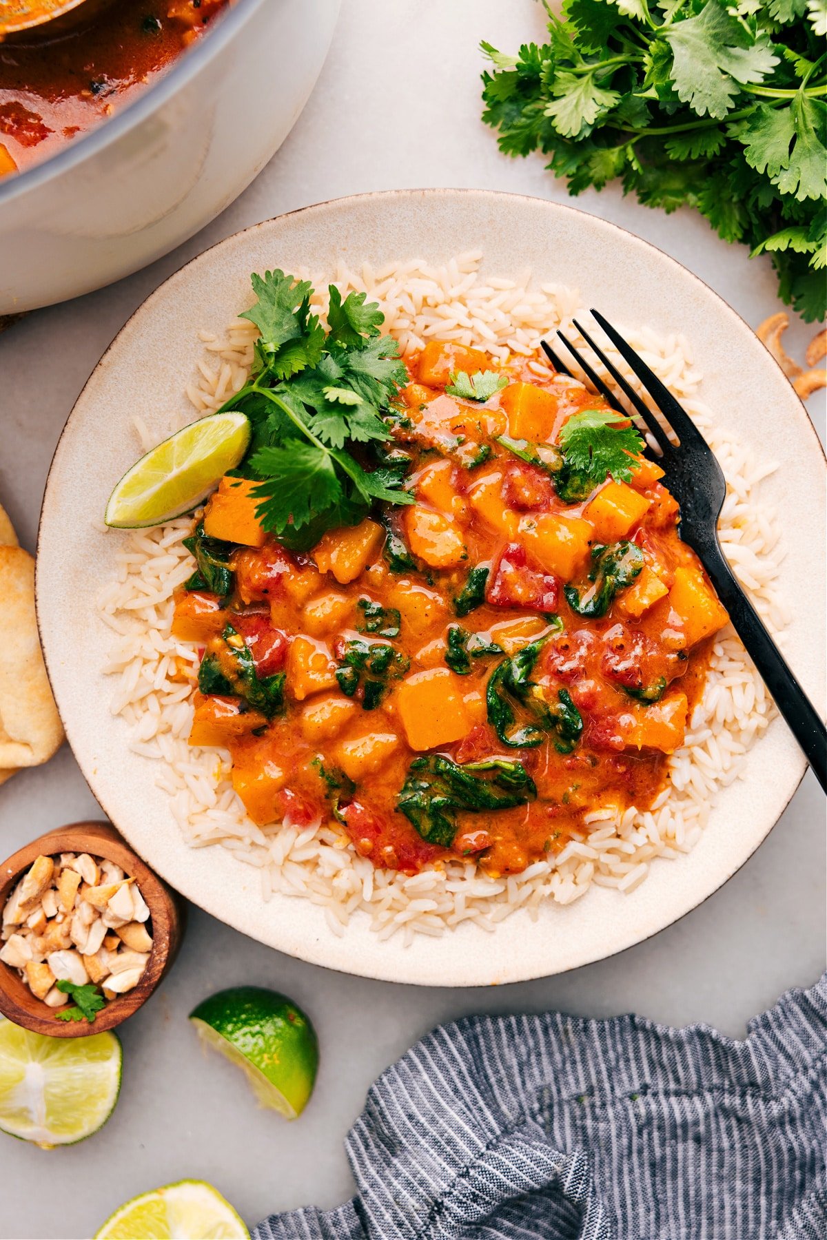 Serve butternut squash curry on a bed of rice, and top it with cilantro and lime.