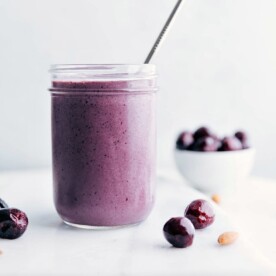 A delicious cherry smoothie with a straw in it, showcasing a vibrant color and smooth texture.