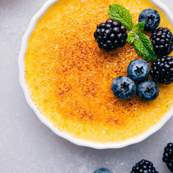 Delicious easy creme brûlée with a caramelized top, garnished with fresh fruit.