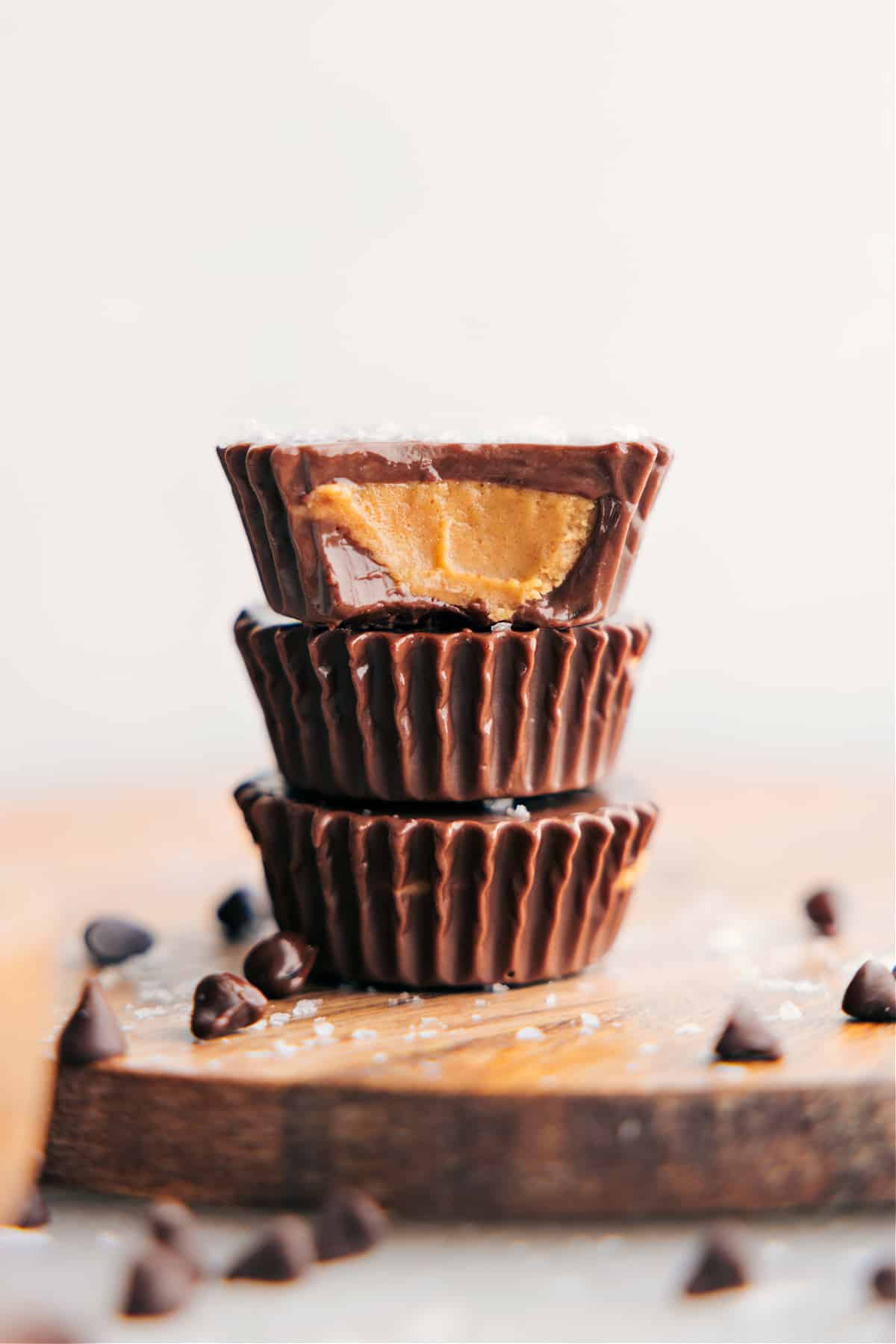 Homemade Peanut Butter Cups stacked on top of each other with a bite out of one of them showing the delicious inside.