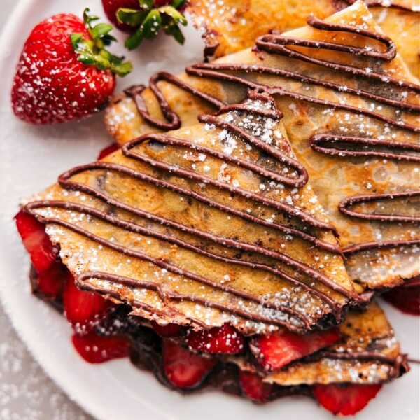 The finished dessert of warm Nutella crepes expertly cooked to achieve the perfect texture, filled with fresh strawberries and Nutella.