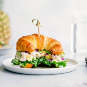 Pineapple chicken salad on a croissant, overflowing with flavorful ingredients, creating the perfect combination of savory and sweet.