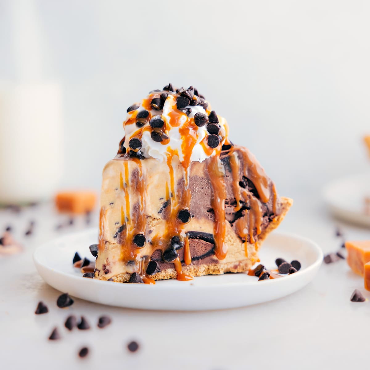 A slice of the ice cream pie dessert recipe on a plate showing the layers of different ice cream and toppings.