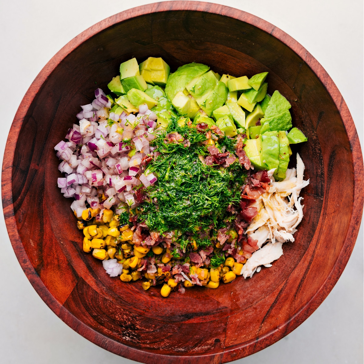 All the ingredients in this recipe added to a bowl ready to be tossed together with the dressing.