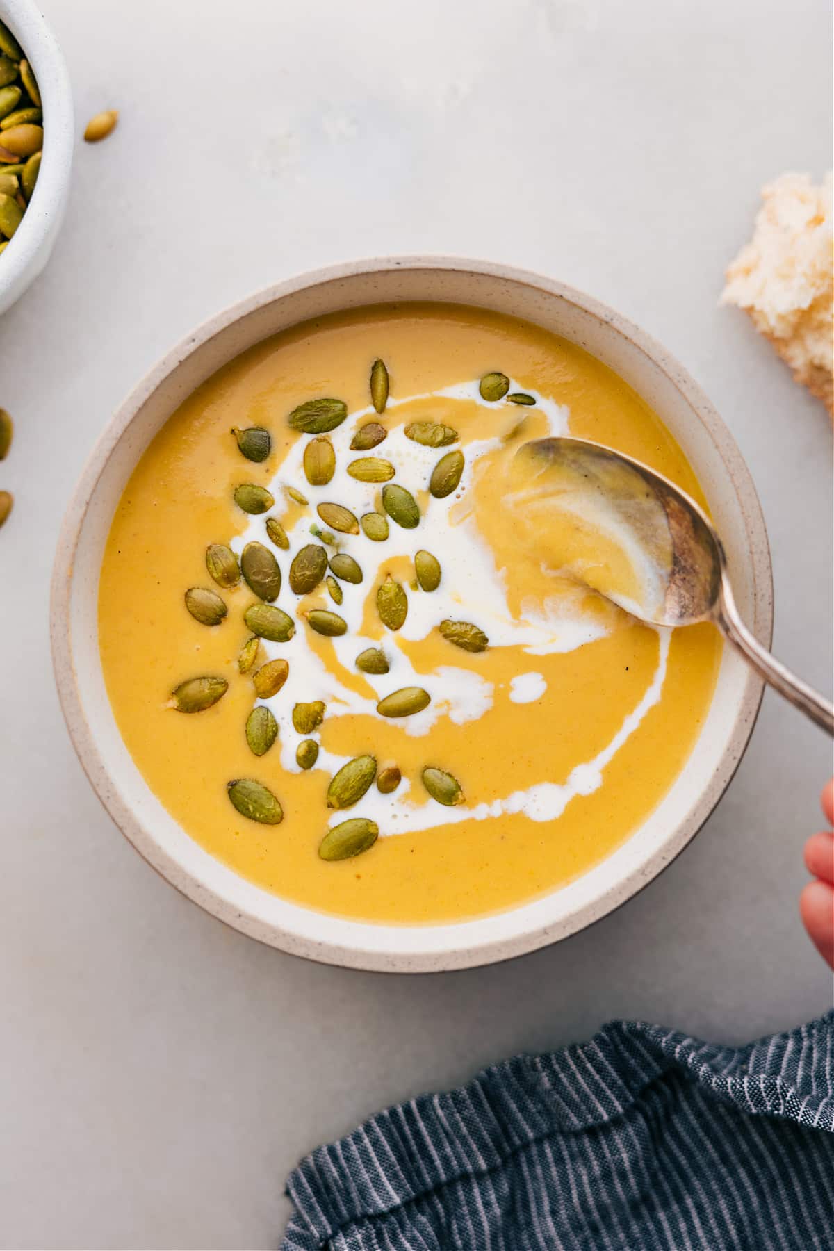 Butternut squash soup in a bowl topped with pepitas.