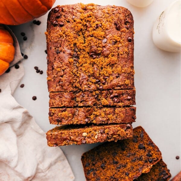 Pumpkin chocolate chip bread with slices cut out, revealing the delicious and fluffy interior.