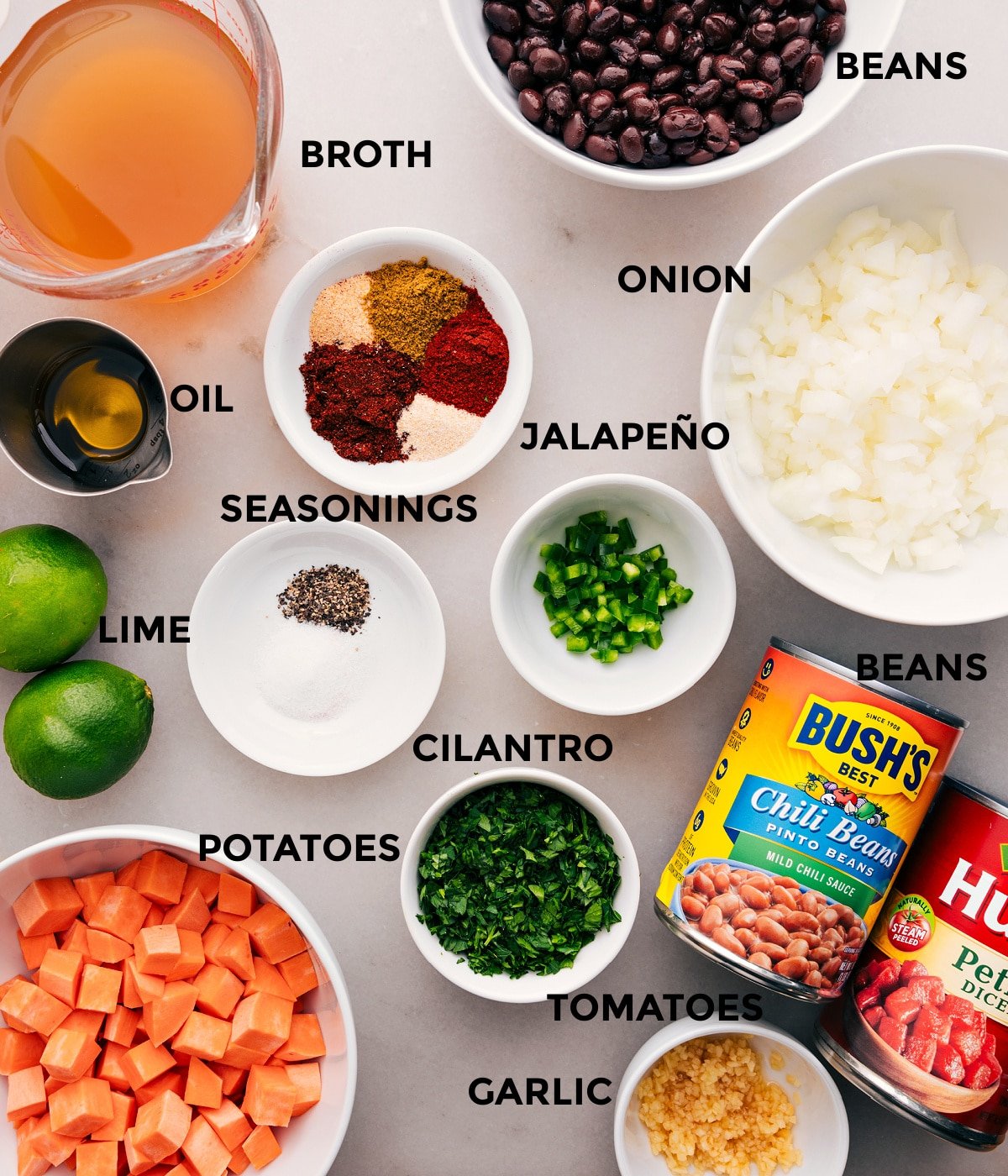 All the ingredients for this recipe—veggies, seasonings, beans, limes, broth, and tomatoes—are prepped and ready for easy assembly.