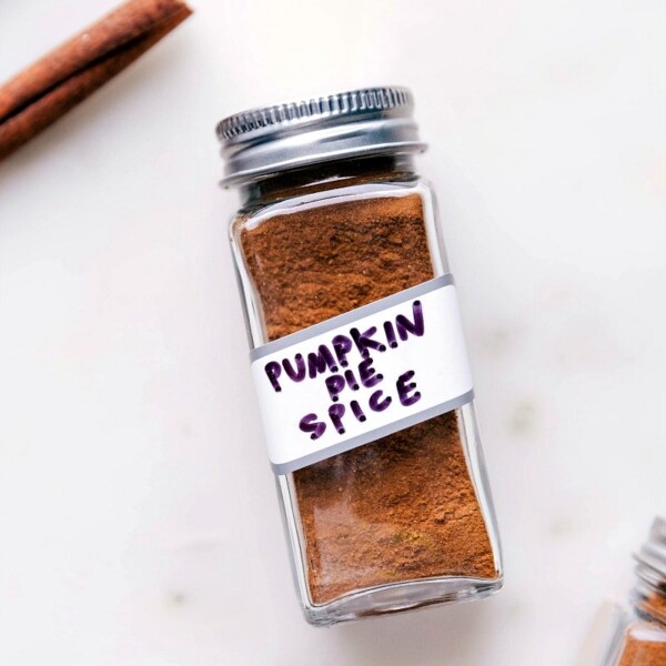 Container of aromatic pumpkin pie spice, a perfect addition to fall recipes.