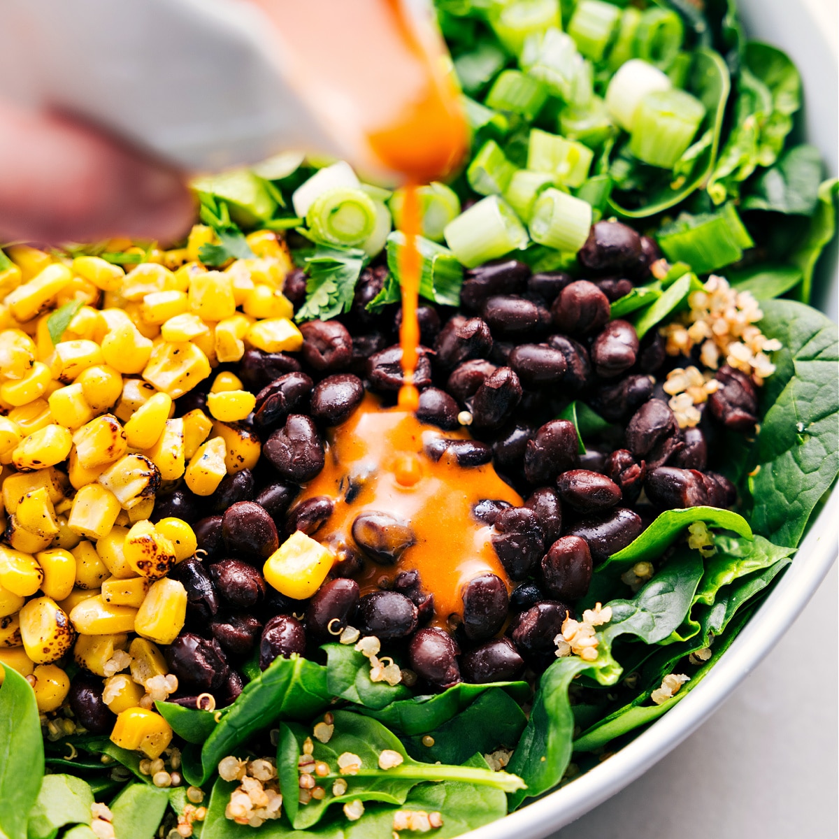 Assembled Quinoa Corn Salad with chipotle-lime vinaigrette drizzled on top.