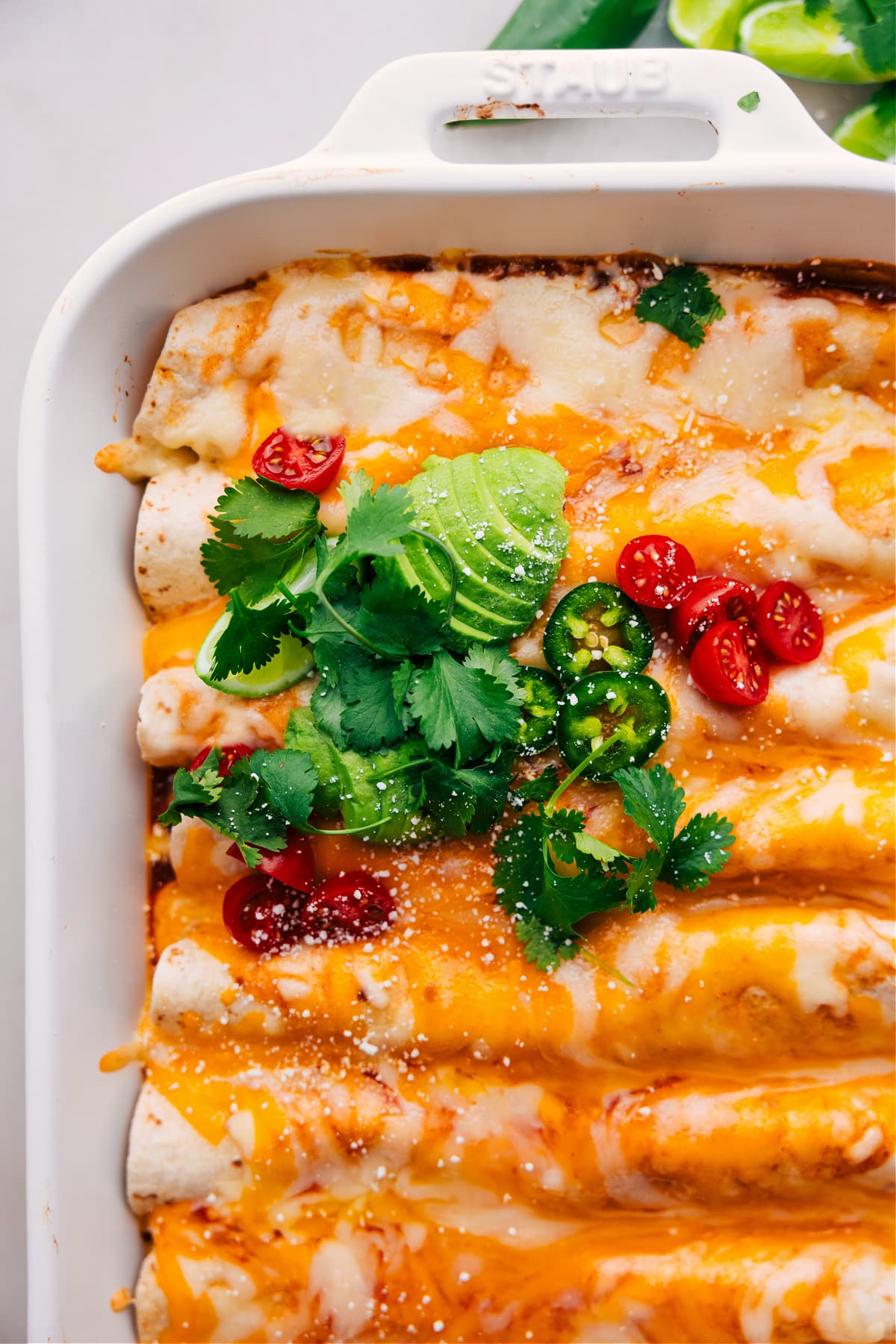 Vegetarian Enchiladas fresh out of the oven, loaded with avocado, tomatoes, jalapeño, and cilantro.