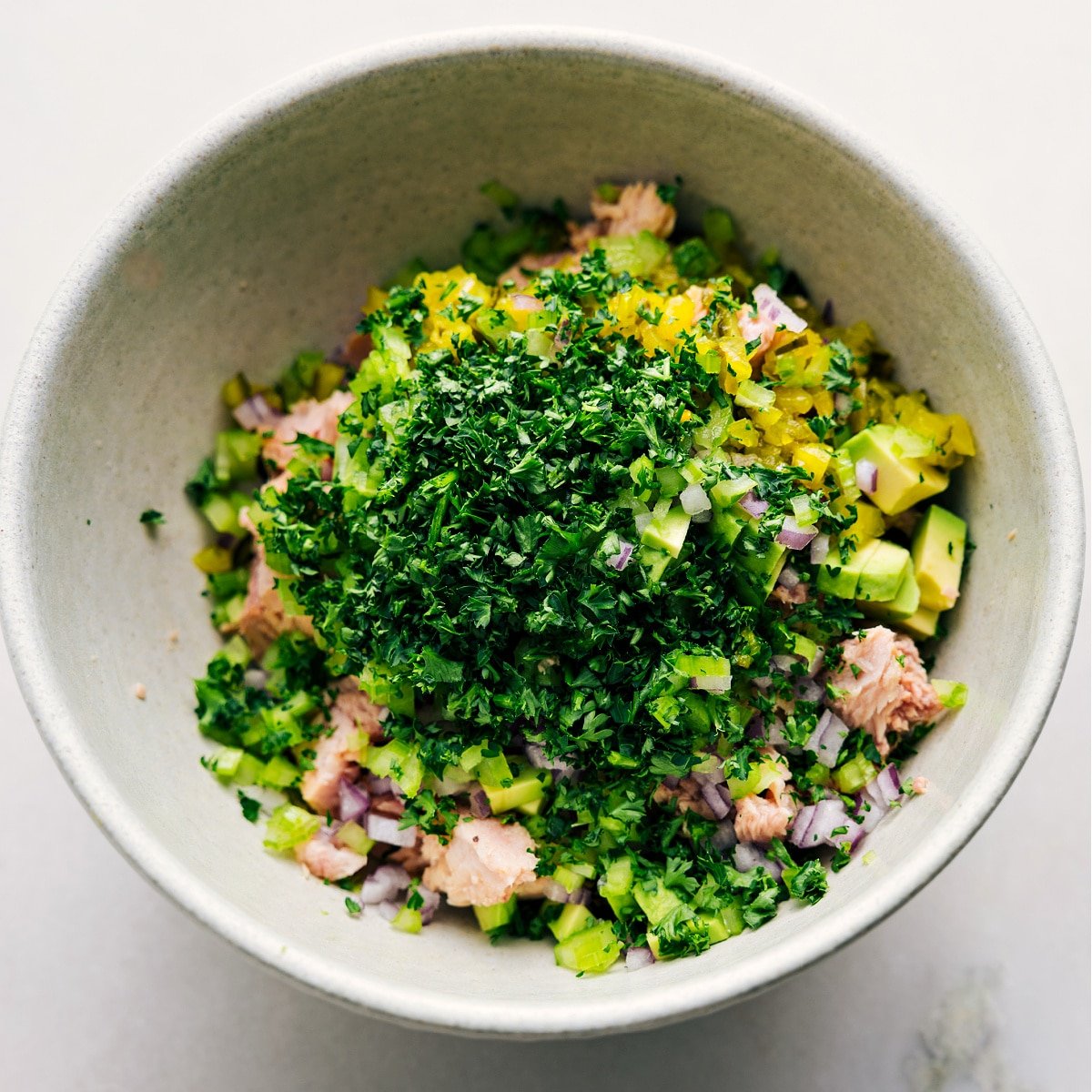 All the ingredients are in a bowl, ready to be tossed for this Avocado Tuna Salad.