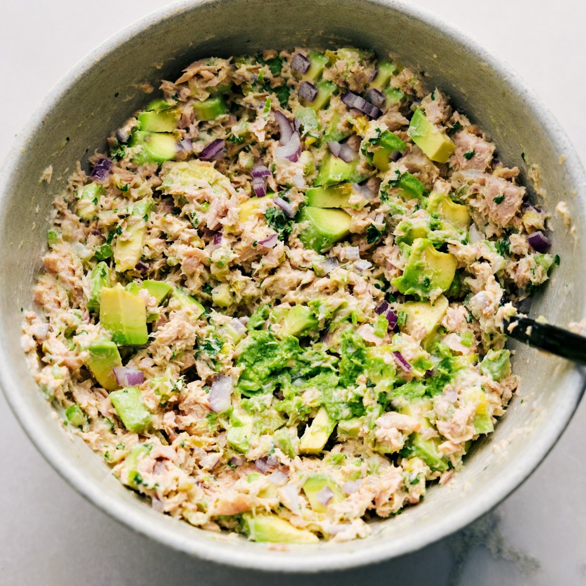 The Avocado Tuna Salad is tossed together in a bowl, ready to be served on bread as a sandwich or enjoyed however you like.