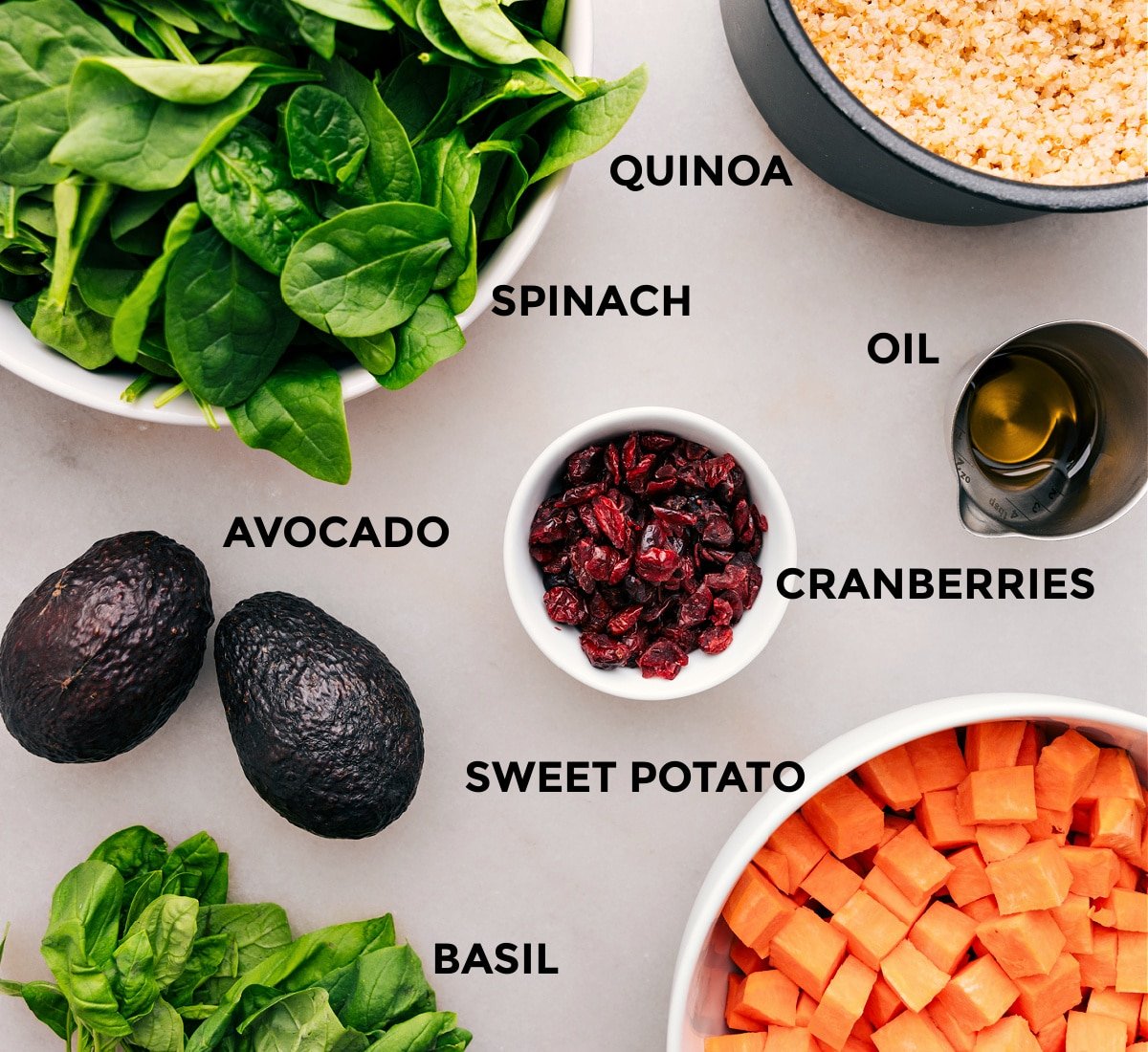 All the ingredients—veggies, grains, cranberries, oil, and avocado—are prepped for easy assembly.