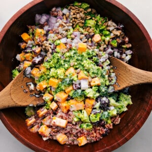 The broccoli salad in a bowl ready to be tossed together.