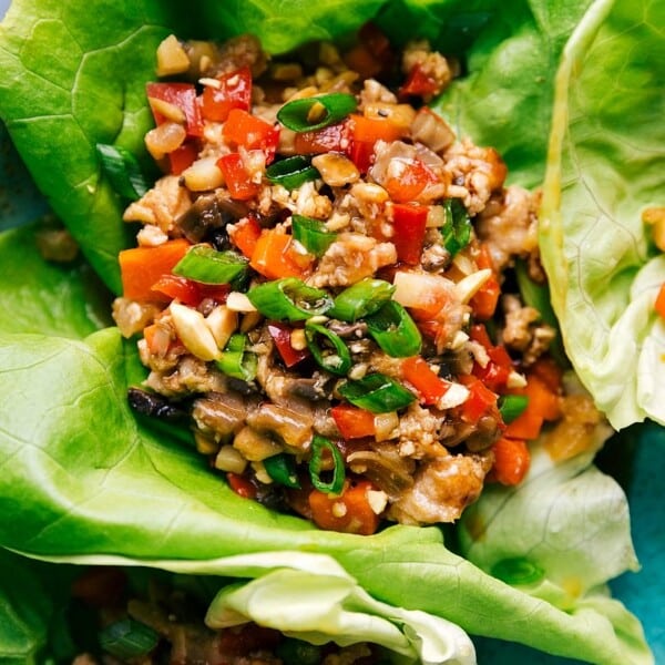 Chicken lettuce wraps garnished with herbs and vegetables.