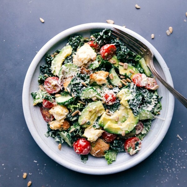 Fresh kale avocado salad, garnished and ready to eat, featuring lush greens, creamy avocado slices, and added toppings.