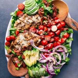 Platter of fresh, healthy salad drizzled with honey mustard salad dressing, inviting and ready to enjoy.