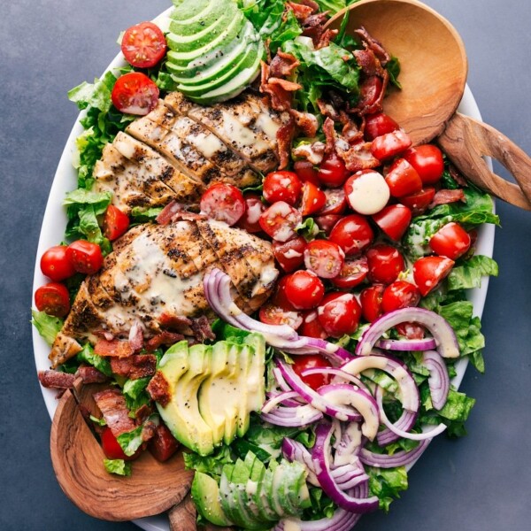 Platter of fresh, healthy salad drizzled with honey mustard salad dressing, inviting and ready to enjoy.